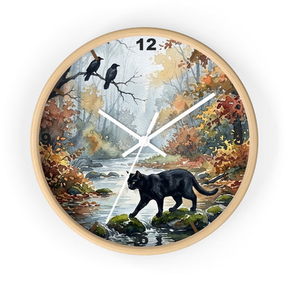 Round wall clock with a light wood frame and a printed nature scene on the face, featuring a black cat by a stream, two crows on branches, autumn foliage, and white clock hands. 