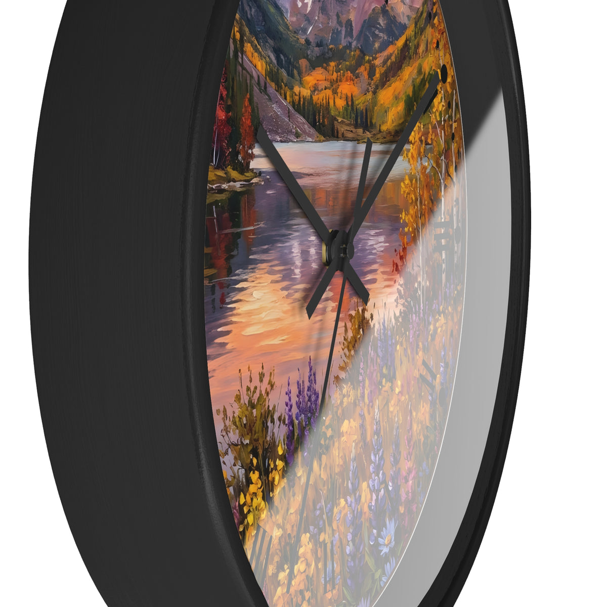 Round wall clock with a black frame and a scenic autumn landscape print featuring a lake, mountains, and colorful wildflowers, shown against a white background.