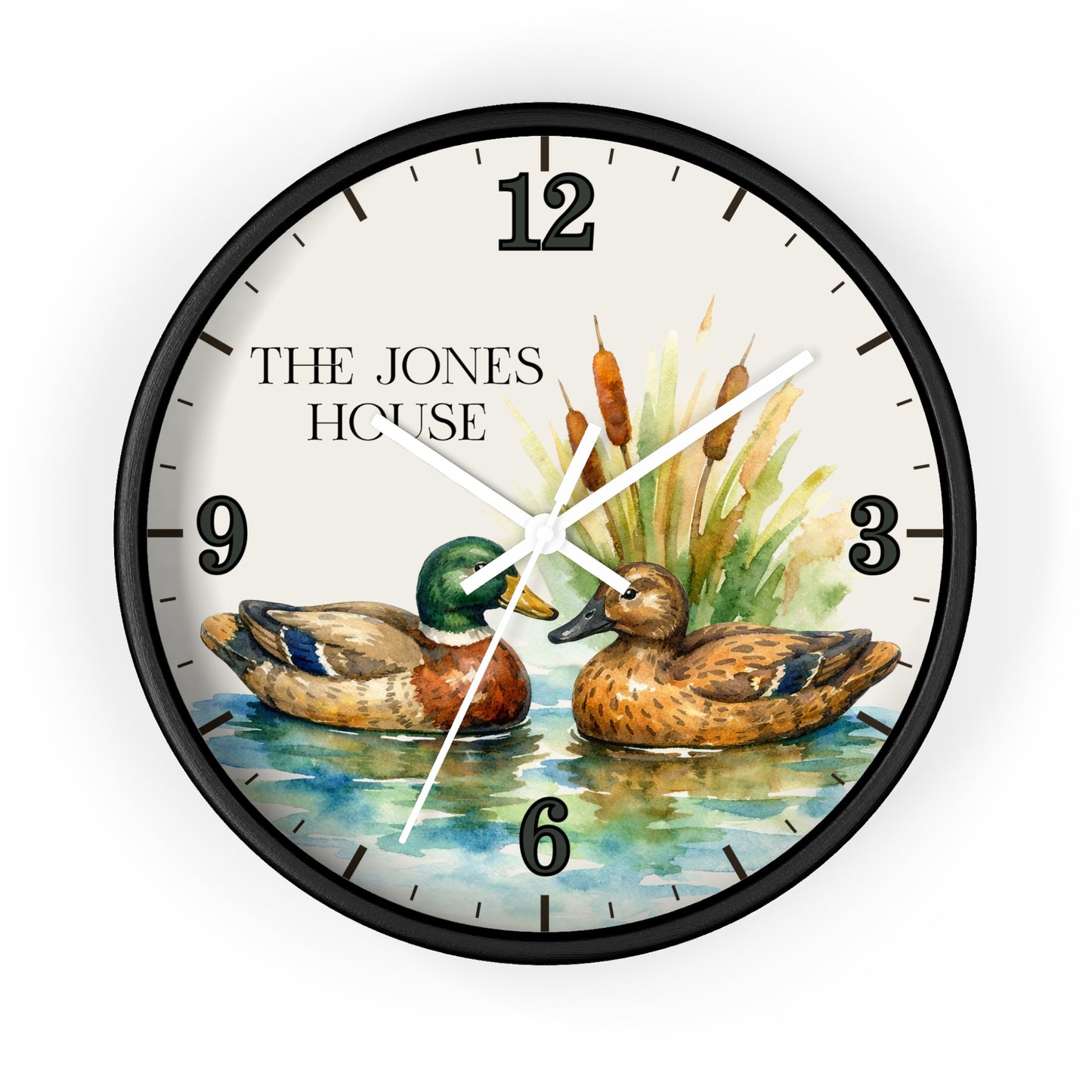 A round wall clock with a black frame and a printed dial showing two mallards on water, cattails, and the text 'THE JONES HOUSE' at the upper left. The clock is photographed against a plain white background.