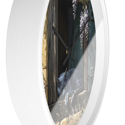 Round wall clock with a white frame and a printed illustration of a gray cat sleeping by a dark wooden door with wisteria flowers, shown against a white background.