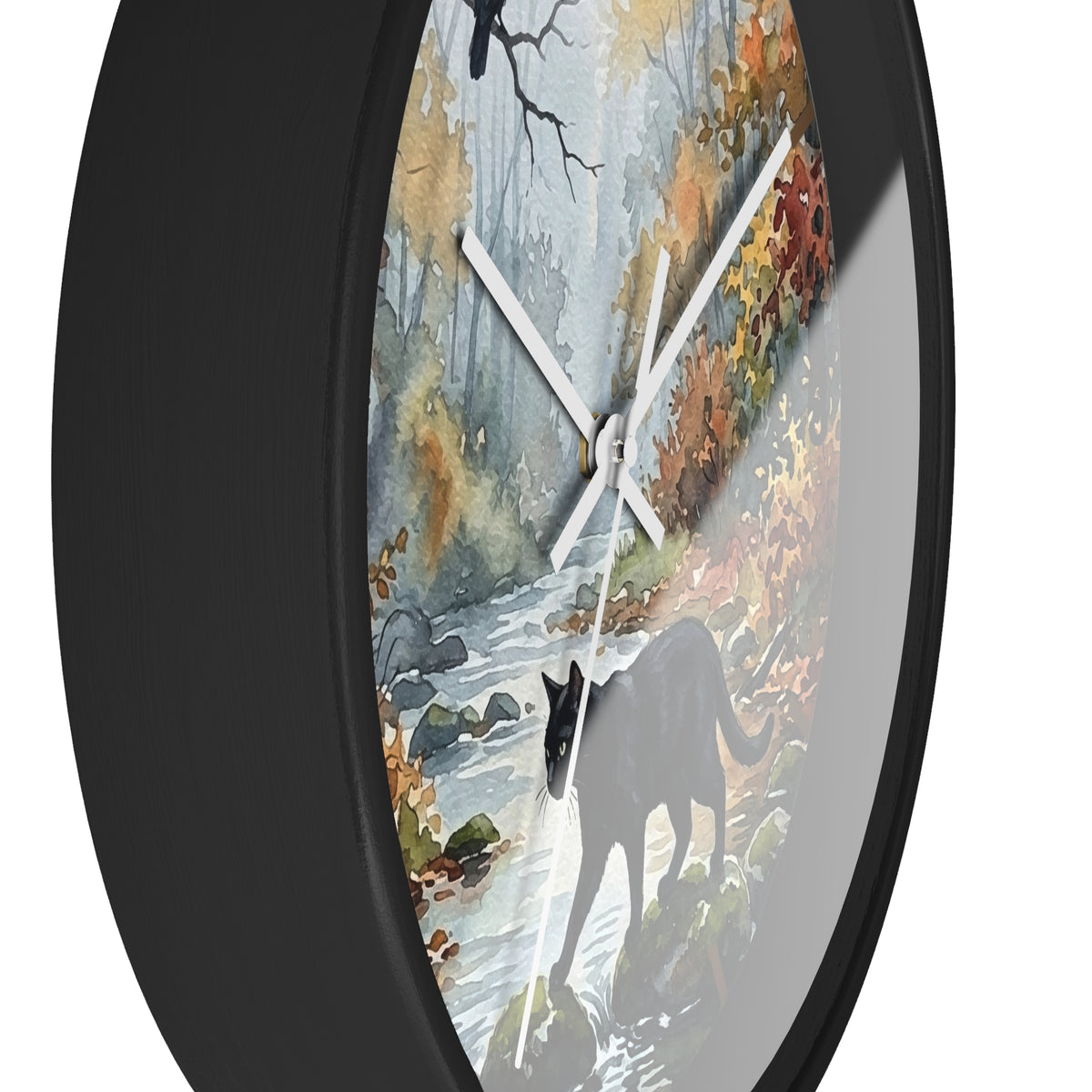 Round wall clock with a black frame and a printed autumn forest scene featuring a black cat walking near a stream. The clock is shown at an angle against a plain white background.