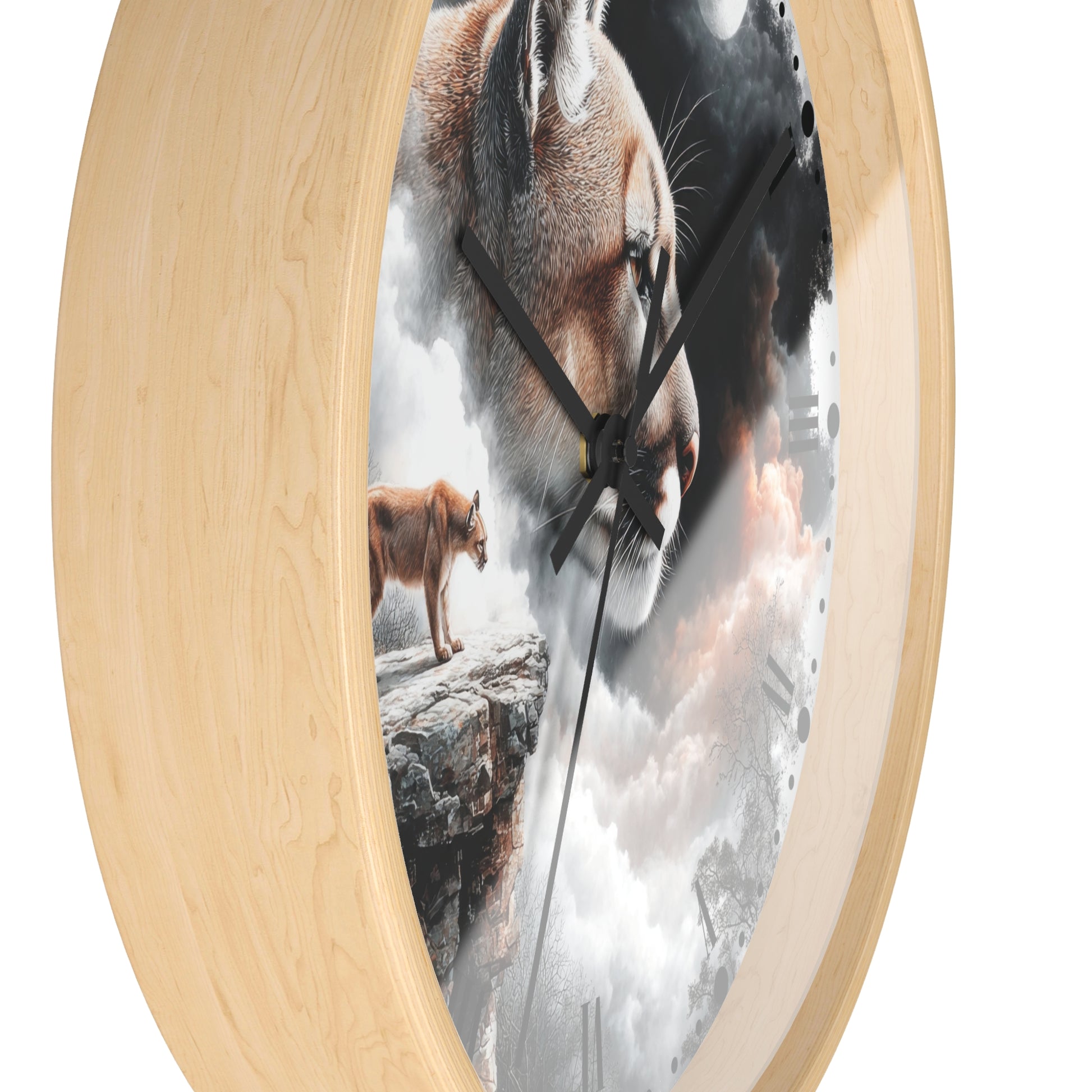 A round wall clock with a light natural wood frame and a printed scenic face showing a large cougar head, a smaller cougar standing on a rock, and cloudy white and gray sky. The clock is shown at an angle against a plain white background.