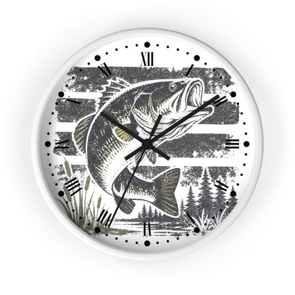 A round wall clock with a white frame and a printed design of a largemouth bass fish jumping over water, set against a background of horizontal gray stripes and pine trees. The clock features black Roman numerals and black hands.