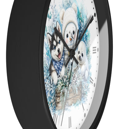 A round wall clock with a black frame and a white face featuring a winter illustration of a husky, a snowman, and a puppy in blue and white tones.