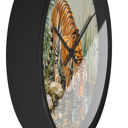 Round wall clock with a black frame and a printed tiger drinking water scene on the face, shown against a plain white background.