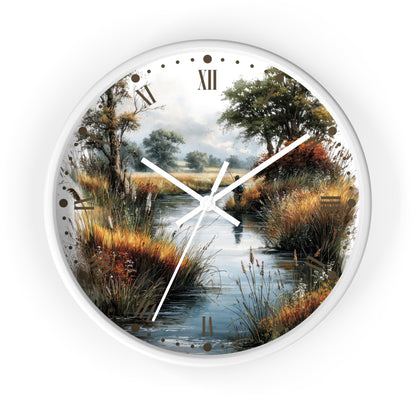 Round wall clock with a scenic landscape print of a marsh or creek, featuring trees, grasses, and a cloudy sky. The clock has a white frame and white hands, with Roman numerals at the top and hour markers placed along the scenic border.
