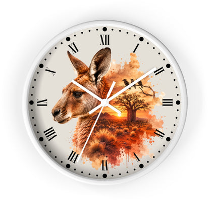 A round wall clock with a white frame and a printed dial featuring a kangaroo head, a tree silhouette, birds, and an orange sunset scene. The clock has black Roman numerals and black dot hour markers on a white background.