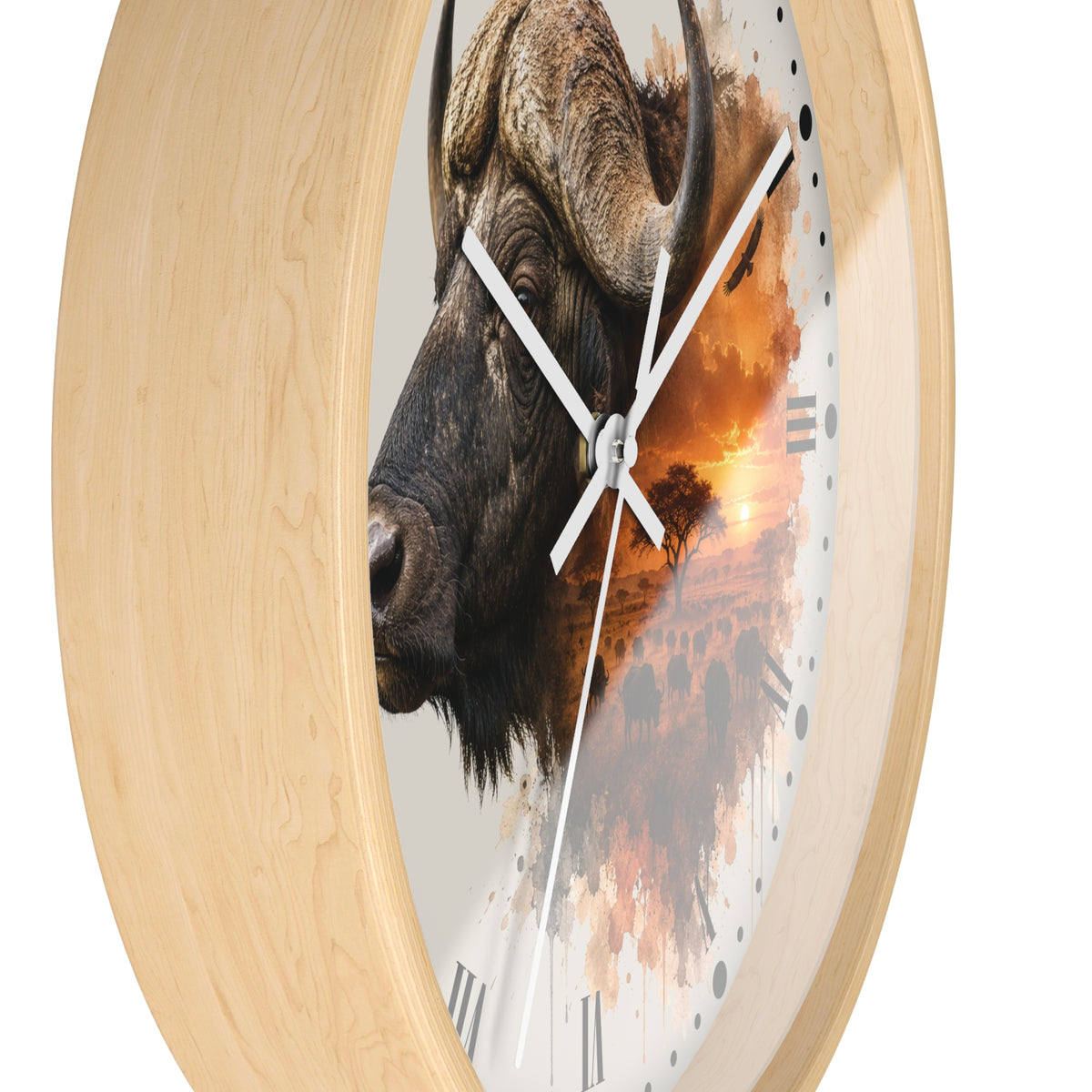 Round wall clock with a light natural wood frame and a printed face featuring a watercolor-style bison head over an orange sunset landscape, with white hands and black Roman numerals.