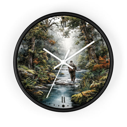 Round wall clock with a black frame and a printed scenic dial showing a person wading through a stream in a forest. The clock has white hands and black Roman numeral markers, photographed against a plain white background.