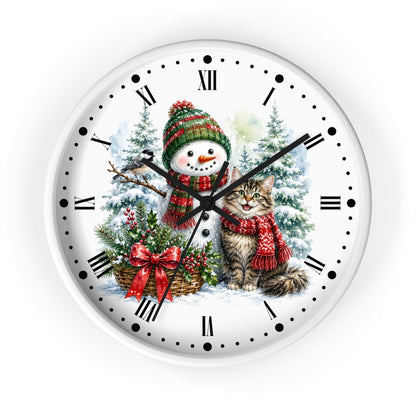 A round white wall clock with a festive Christmas illustration on the face, featuring a snowman in a green and red knit hat and scarf, a gray tabby cat in a red knit outfit, evergreen trees, and a bird, with black Roman numerals and dot hour markers.