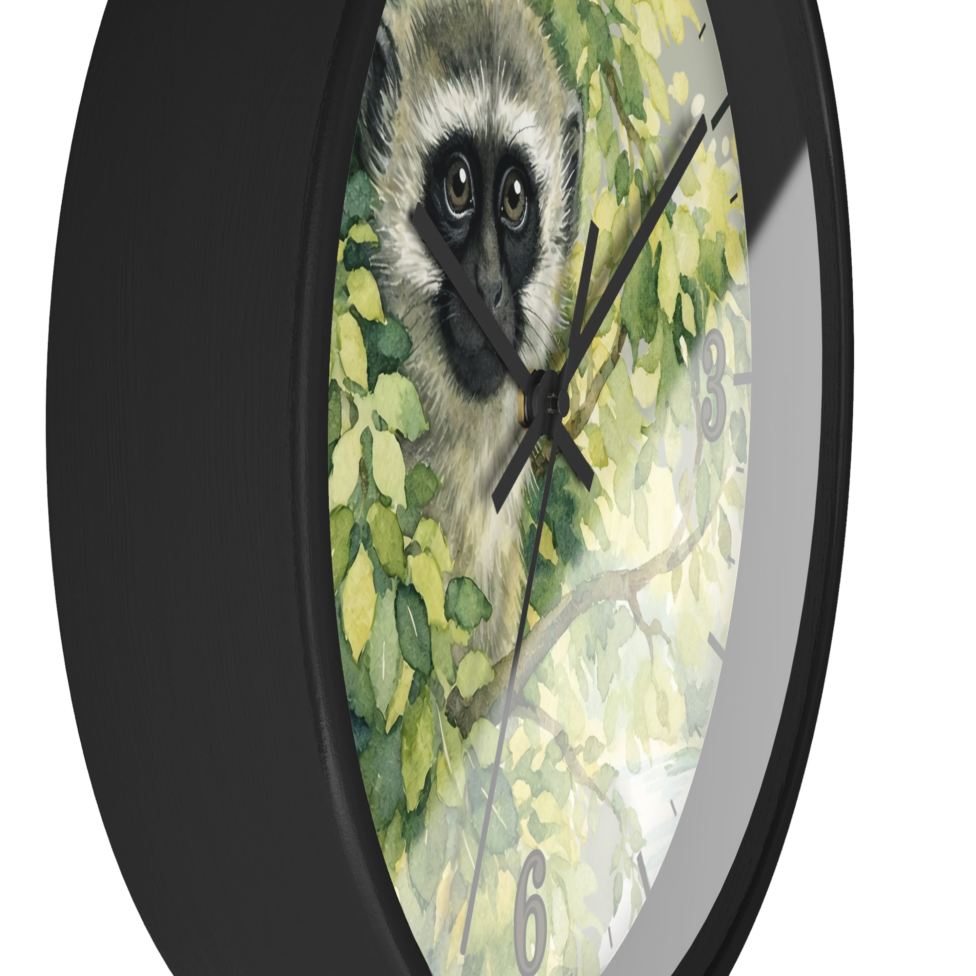 A round wall clock with a black frame and a printed face featuring a vervet monkey among green leaves, shown against a plain white background.