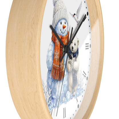 Round wall clock with a light natural wood frame and a white face featuring a winter illustration of a snowman in a knit hat and scarf, a polar bear, and a small bird.