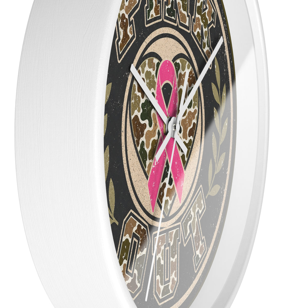 A close-up of a round wall clock with a white frame and a printed face featuring a pink ribbon over a camouflage heart, surrounded by the words 'Cruel Puts'.