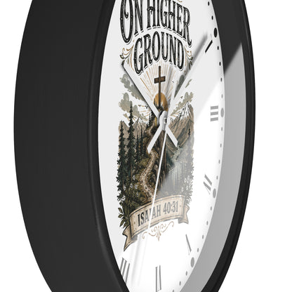 A close-up of a round wall clock with a black frame and a white face featuring a scenic mountain-and-forest illustration, the text 'ON HIGHER GROUND,' and 'ISAIAH 40:31.'.