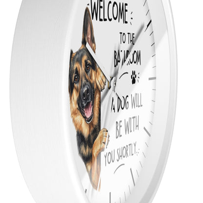 A round white wall clock with a printed German Shepherd illustration and the text 'WELCOME TO THE BATHROOM ROOM A DOG WILL BE WITH YOU SHORTLY.