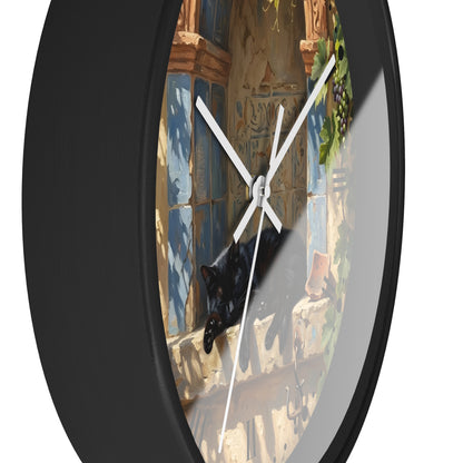 A round wall clock with a black frame and a printed illustration of a black cat lounging on a stone ledge in front of blue tiled windows.