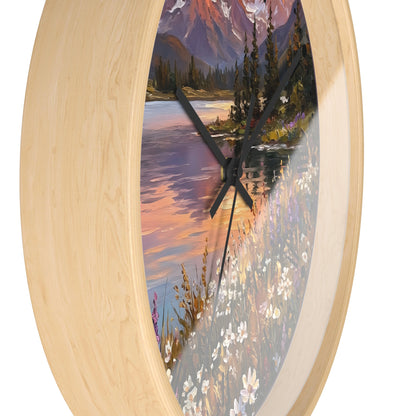 Round wall clock with a light natural wood frame and a printed scenic face showing a mountain lake landscape at sunset with wildflowers, black hands, and a white background.
