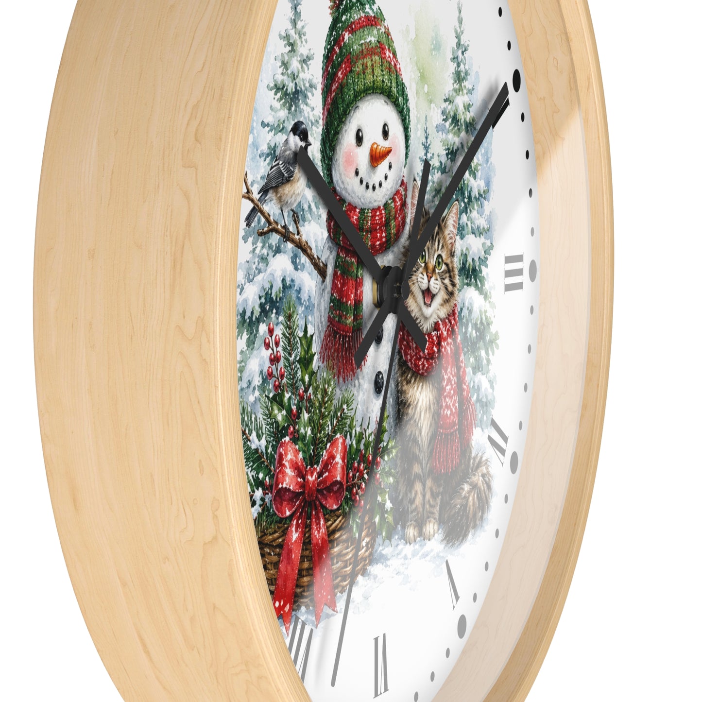 A round wall clock with a light natural wood frame and a white face featuring a winter holiday illustration of a snowman, a cat, evergreen trees, and red bows.
