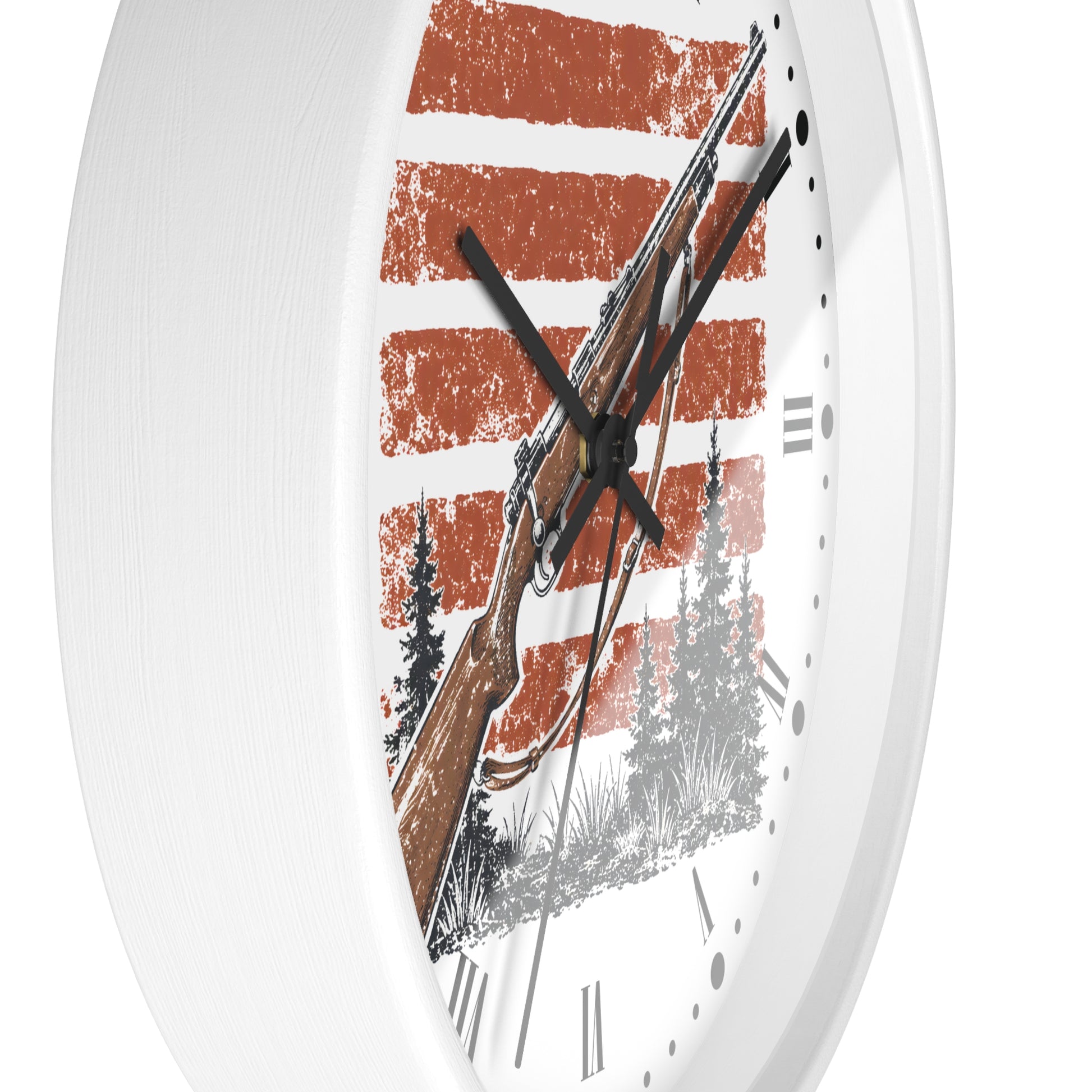 A white round wall clock with a rustic design featuring a rifle, pine trees, and distressed orange and white horizontal stripes on the face.