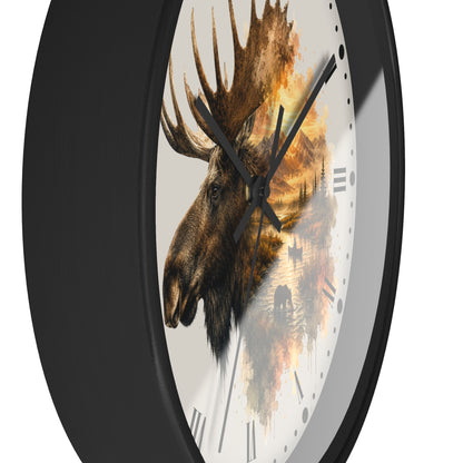 A round wall clock with a black frame and a white face featuring a moose head and an autumn forest scene in warm brown, orange, and yellow tones.