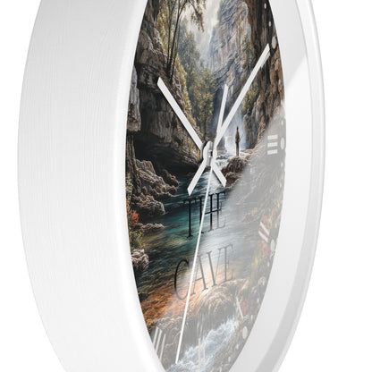Round wall clock with a white frame and a scenic print of a cave interior, river, and waterfall. The words 'THE CAVE' are printed on the dial, and the clock has white hands against a white background.