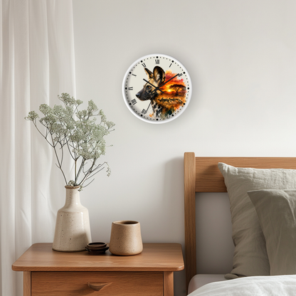 A round wall clock with a white frame and a detailed wild dog illustration in warm orange, brown, and black tones, mounted on a light gray wall above a wooden nightstand in a bedroom setting.