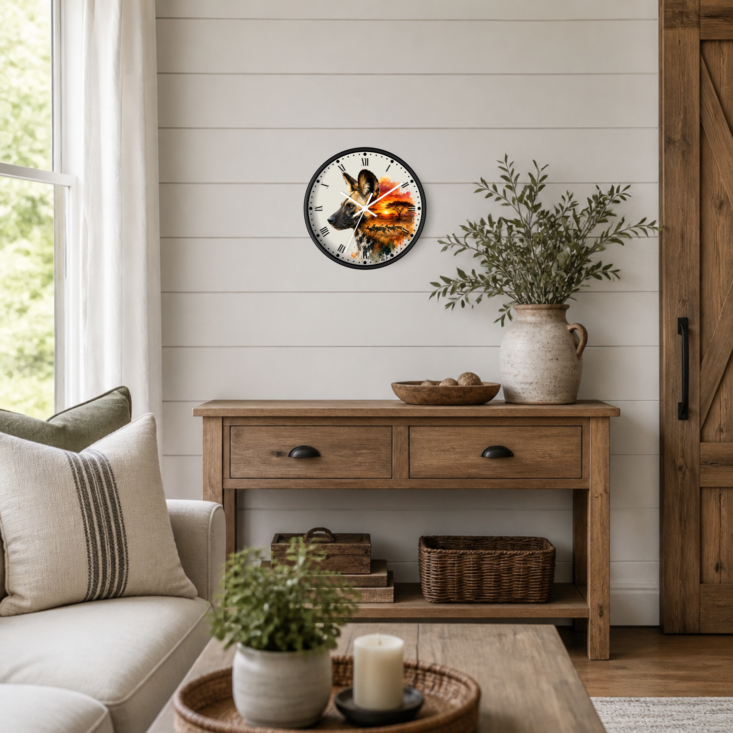 A round wall clock with a rustic wood-grain face and black Roman numerals hangs on a white shiplap wall above a wooden console table in a styled living room.