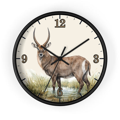 A round wall clock with a black frame and a cream-colored face featuring a detailed illustration of a waterbuck standing in grassy terrain. The clock has black hour and minute hands and black numerals from 1 to 9, with the 12 positioned at the top.