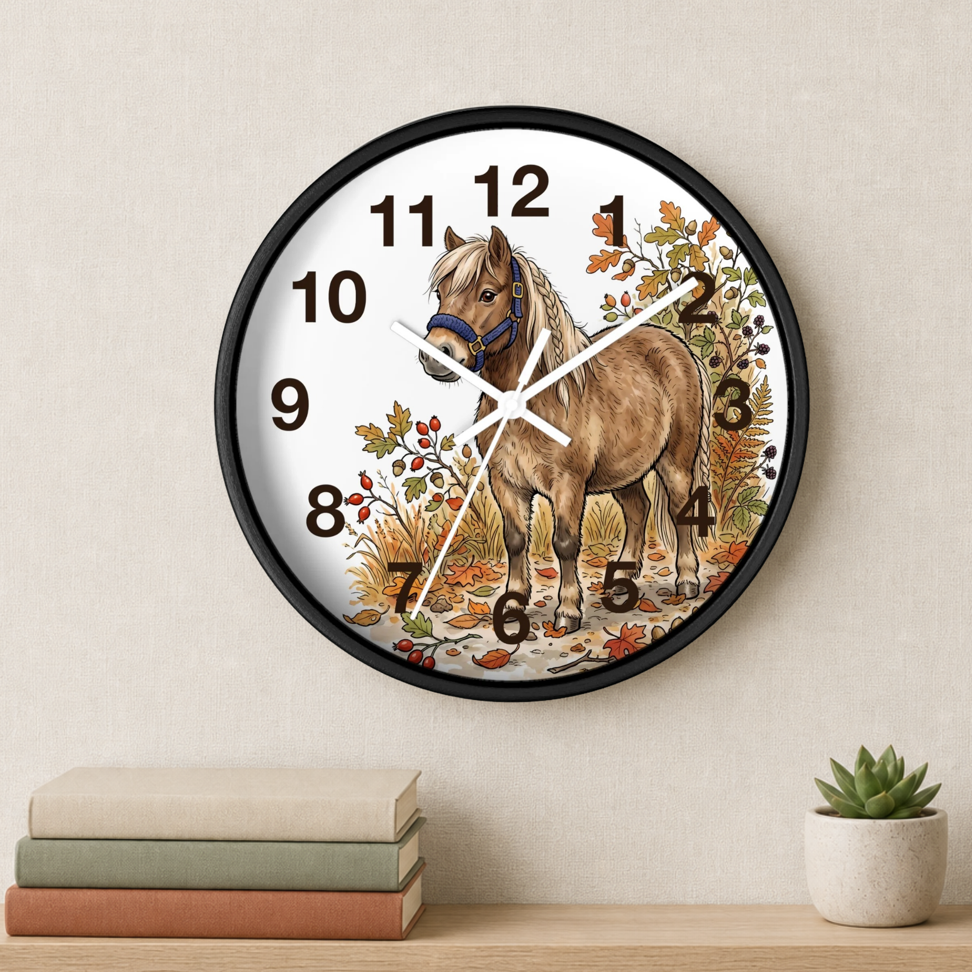 Round wall clock with a black frame and a printed illustration of a brown horse on a white face, styled on a beige wall above a shelf with books and a small succulent.