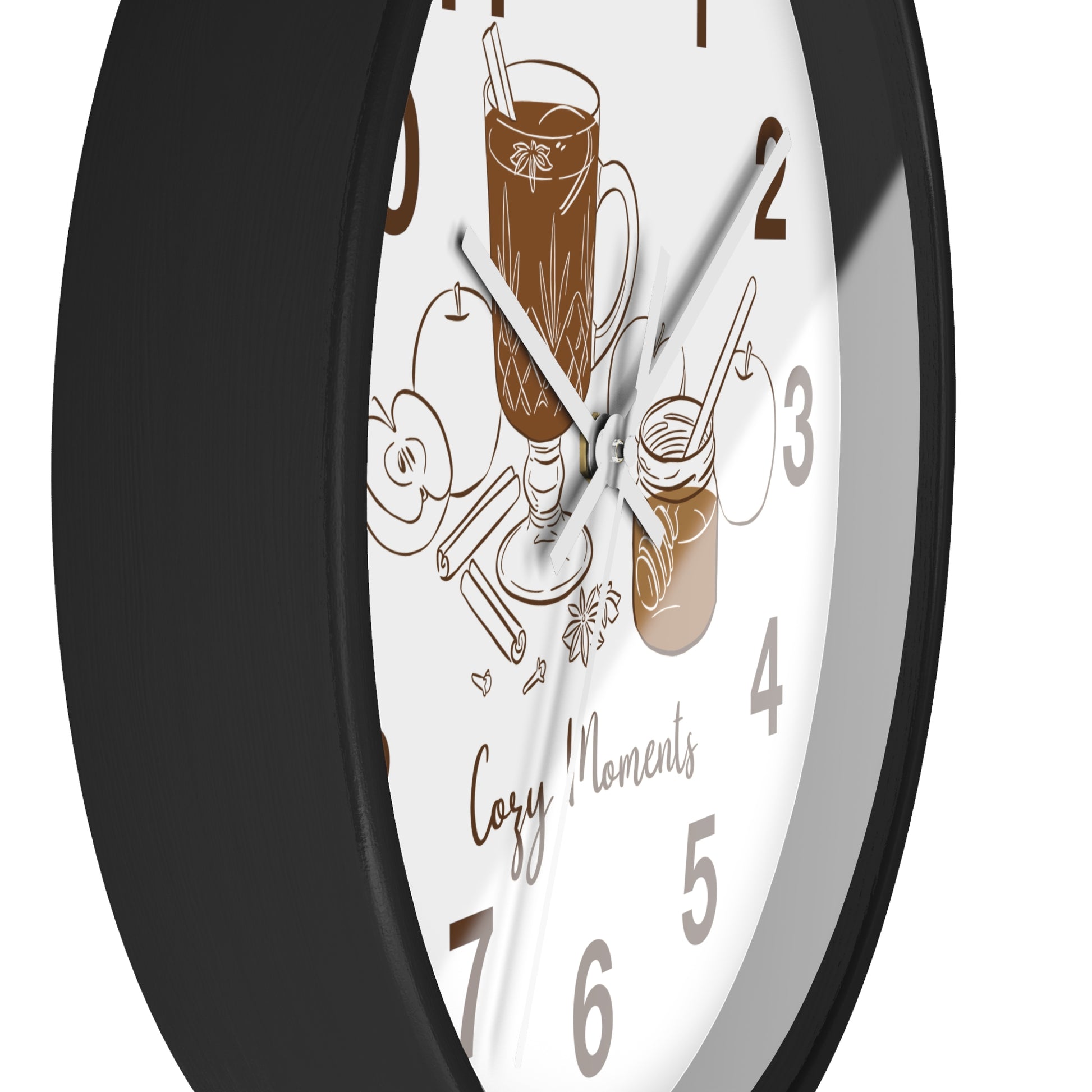 A close-up of a round wall clock with a black frame and a white face featuring brown coffee-themed illustrations and the words 'Cozy Moments'.
