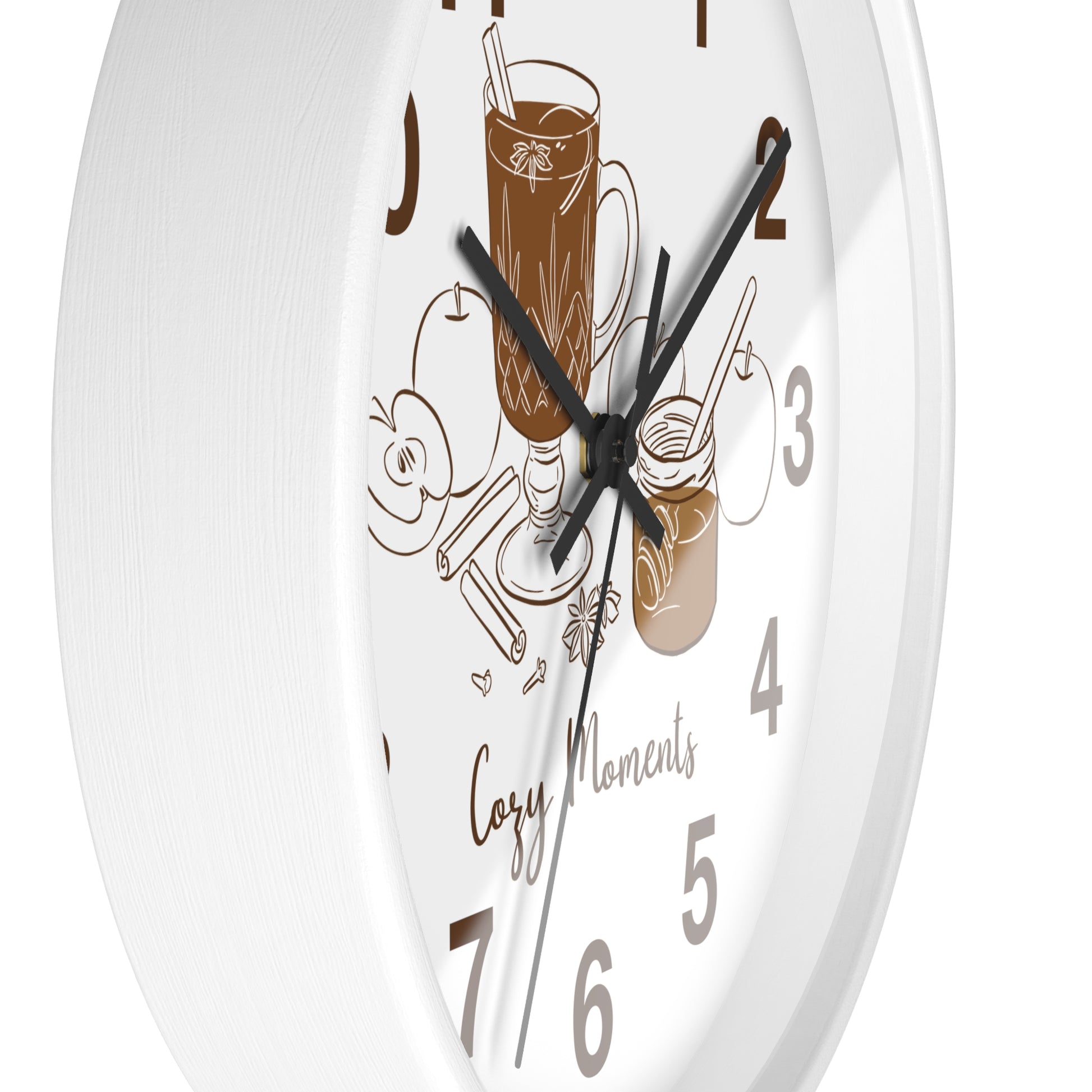 A white round wall clock with black hands and numerals, decorated with brown line-art illustrations of a mug of iced coffee, a jar, and the words 'Cozy Moments'.