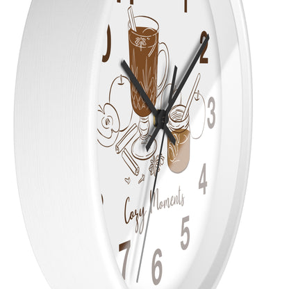 A white round wall clock with black hands and numerals, decorated with brown line-art illustrations of a mug of iced coffee, a jar, and the words 'Cozy Moments'.