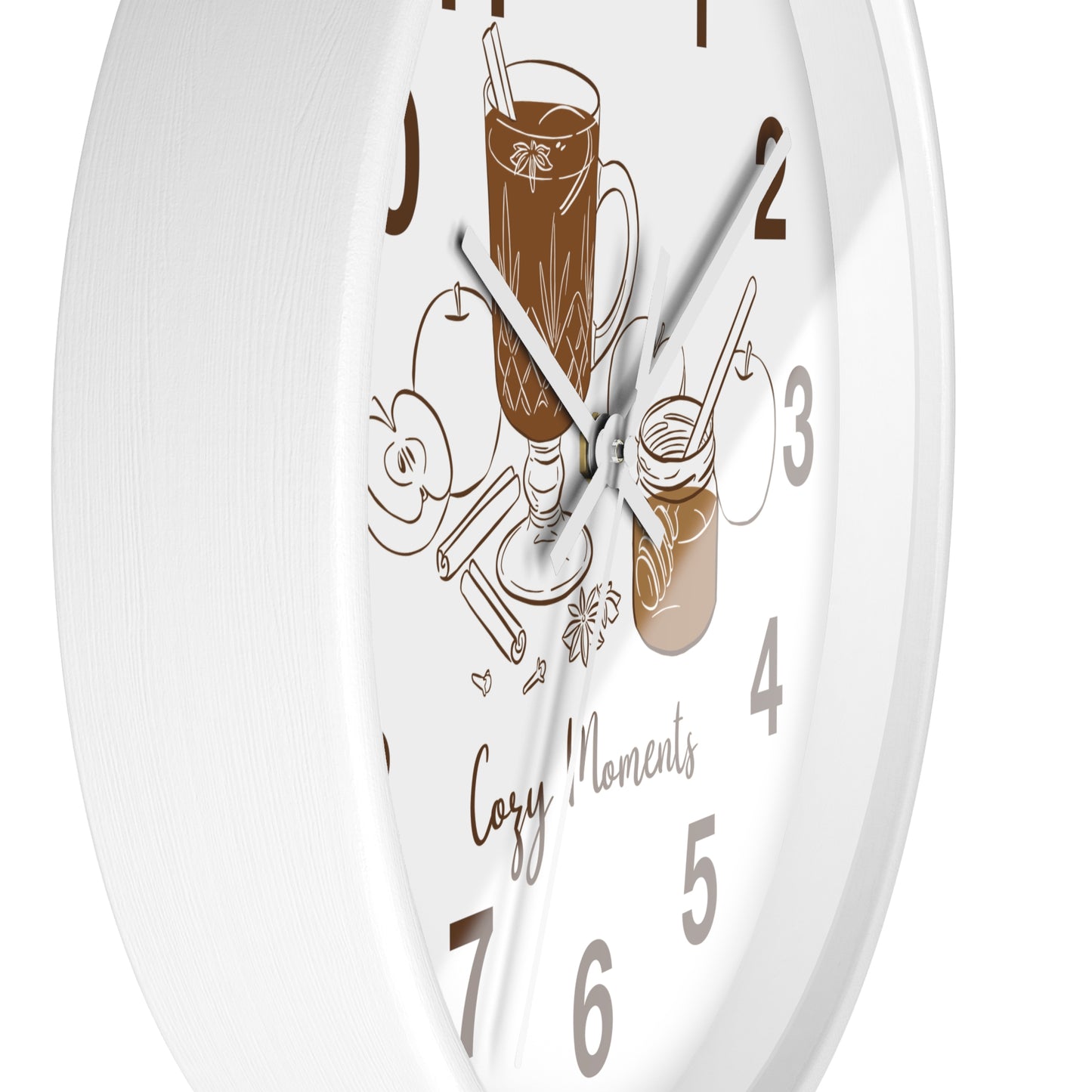 A white round wall clock with a minimalist coffee-themed illustration on the face, featuring brown numerals and the words 'Cozy Moments' near the bottom.
