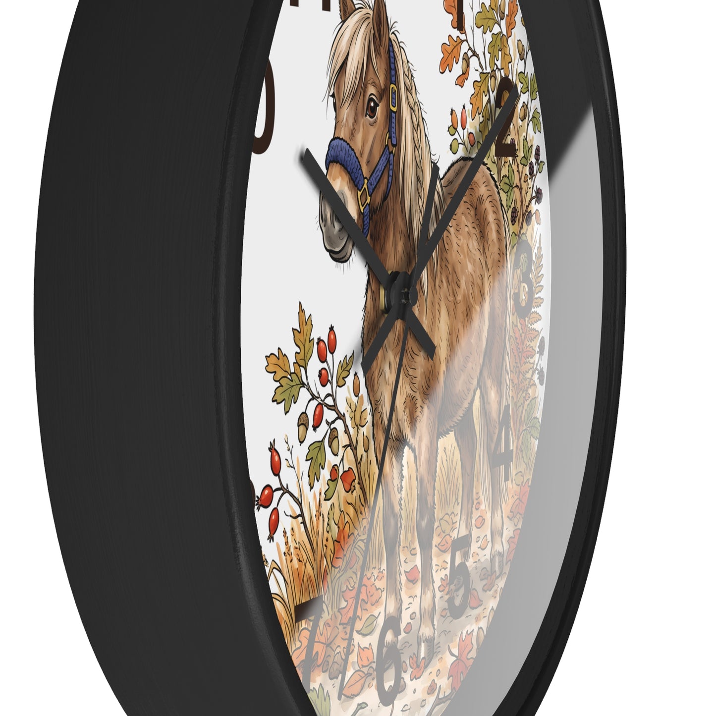 A round wall clock with a black frame and a printed illustration of a brown horse wearing a blue halter, surrounded by autumn foliage, shown against a white background.