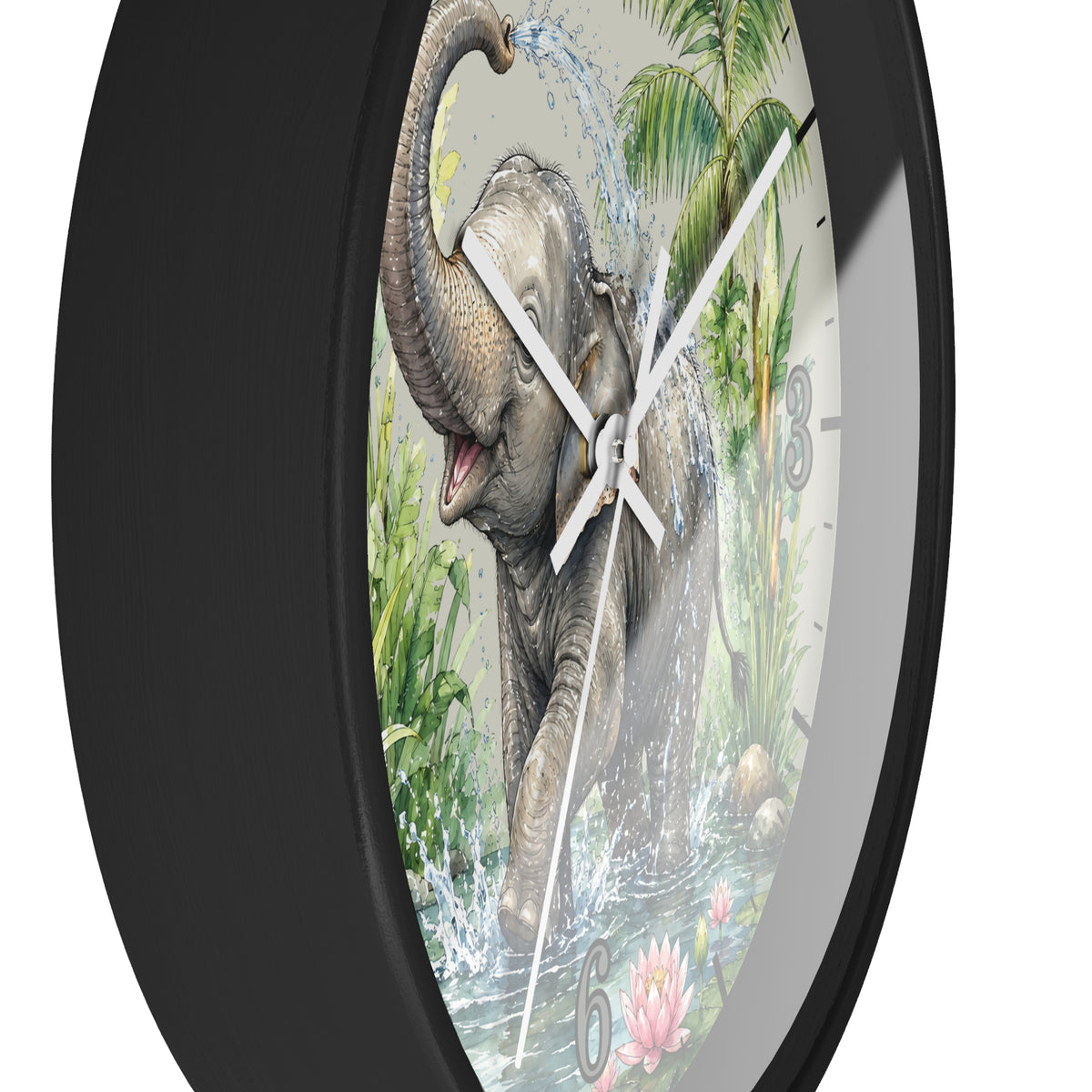A round wall clock with a black frame and a printed elephant scene on the face. The artwork shows a gray elephant spraying water from its trunk in a tropical setting with green foliage, water splashes, and white clock hands.