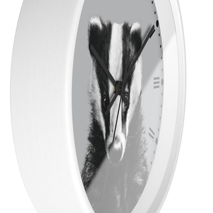 A white oval wall clock featuring a black and white photograph of a badger face in the center, with black hands and Roman numeral hour markers.
