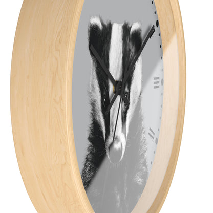 Round wall clock with a light natural wood frame and a grayscale print of a badger face on the dial, shown against a plain white background.