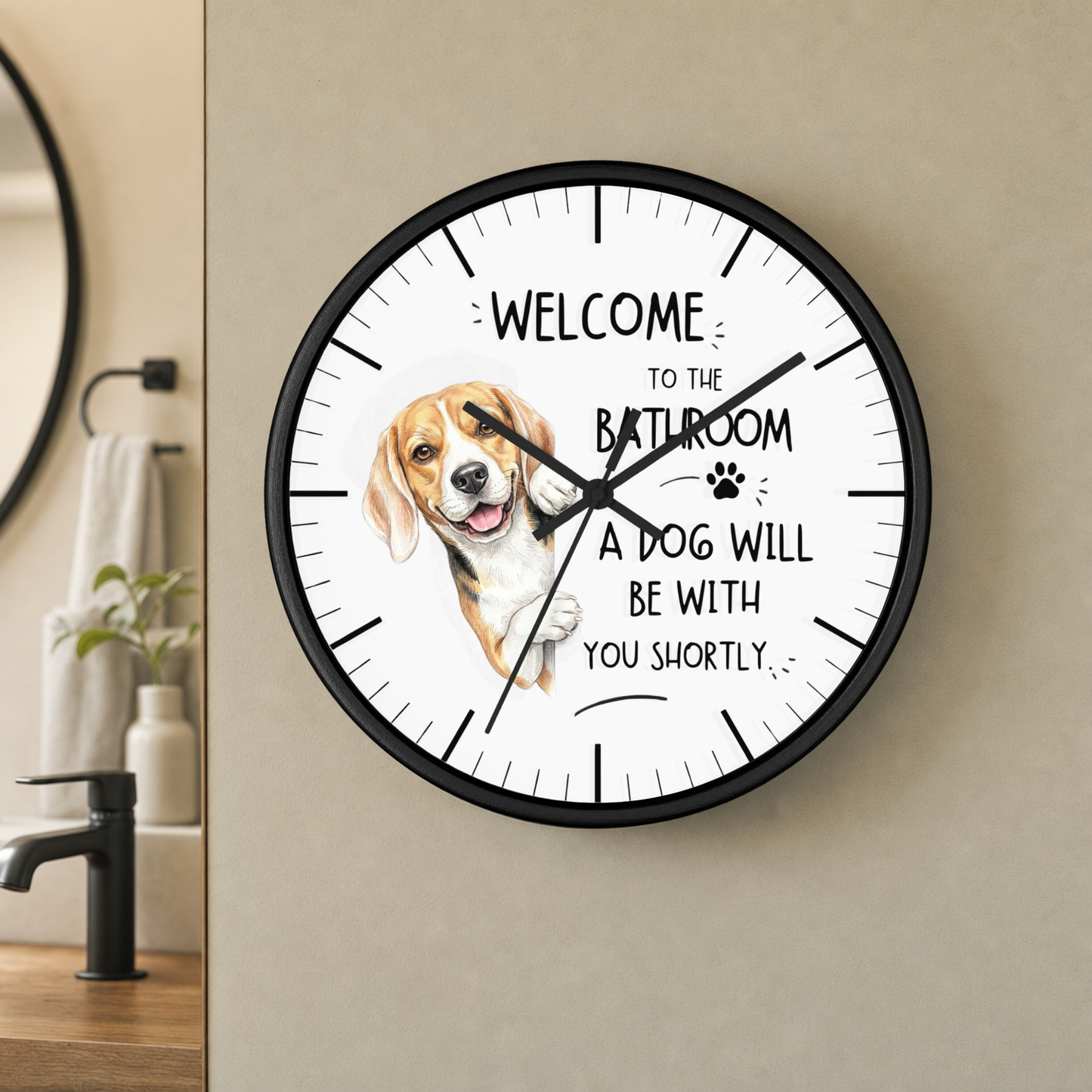A round wall clock with a black frame and a white face, mounted on a beige wall in a bathroom setting. The clock features a painted beagle illustration and the text 'WELCOME TO THE BATHROOM A DOG WILL BE WITH YOU SHORTLY'.