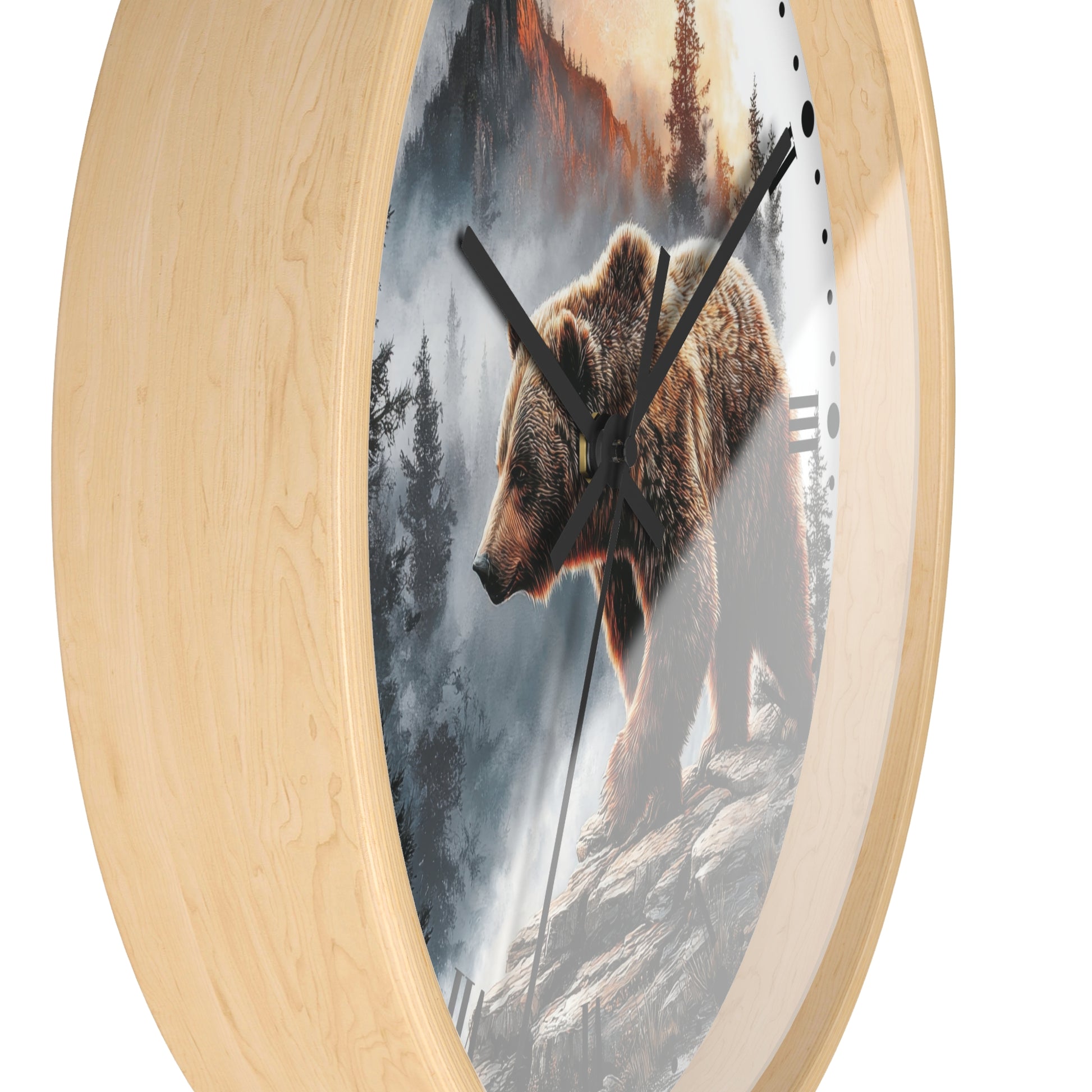 Round wall clock with a light natural wood frame and a printed scenic face showing a brown bear standing on a rocky cliffside in a misty forest landscape. Black clock hands and small black hour markers are visible against a plain white background.
