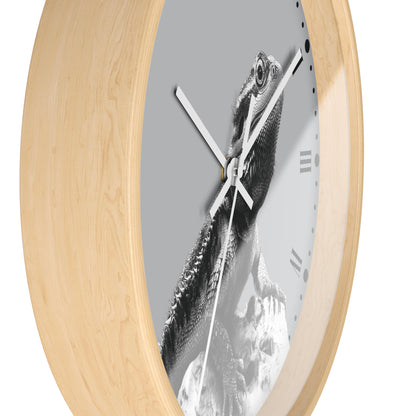 Oval wall clock with a light natural wood frame and a gray dial featuring a black and white bearded dragon lizard print, shown on a white background.