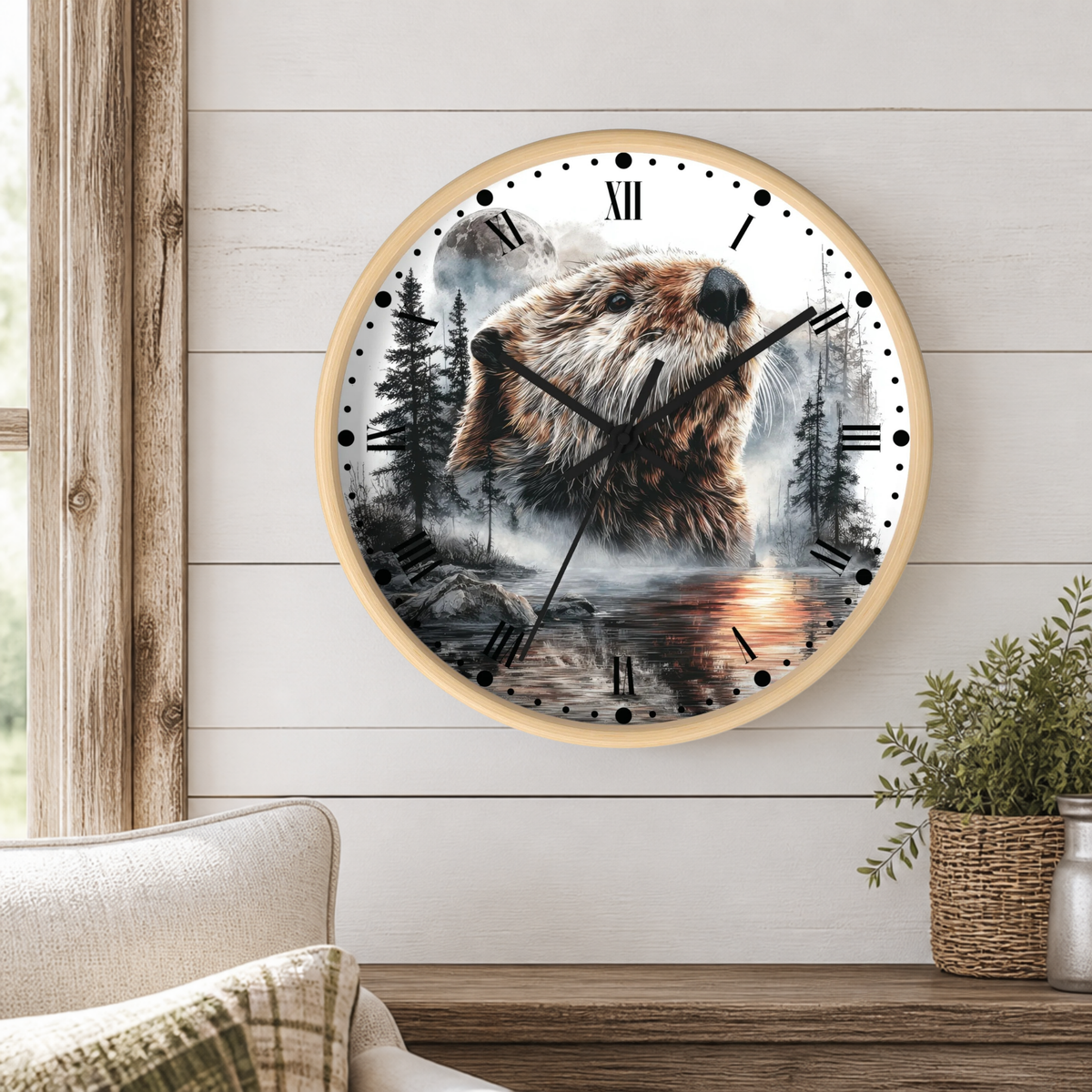 A round wall clock with a light wood frame hangs on a white shiplap wall above a wooden table. The clock face features a detailed illustration of a beaver in a misty forest scene with black Roman numerals and black hands.