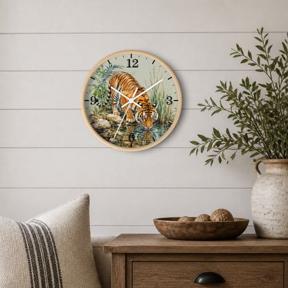 Round wall clock with a natural wood frame featuring a detailed illustration of a tiger drinking water, styled on a white shiplap wall above a wooden side table with a plant and decorative bowl.