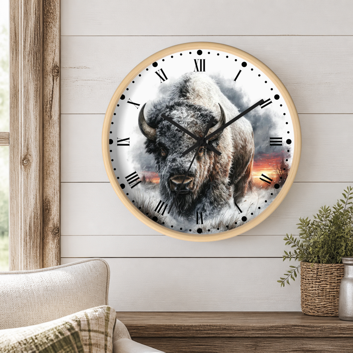 A round wall clock with a light wood frame hangs on a white shiplap wall above a wooden mantel. The clock face features a detailed photograph of a bison with a smoky, dramatic background and black Roman numerals.