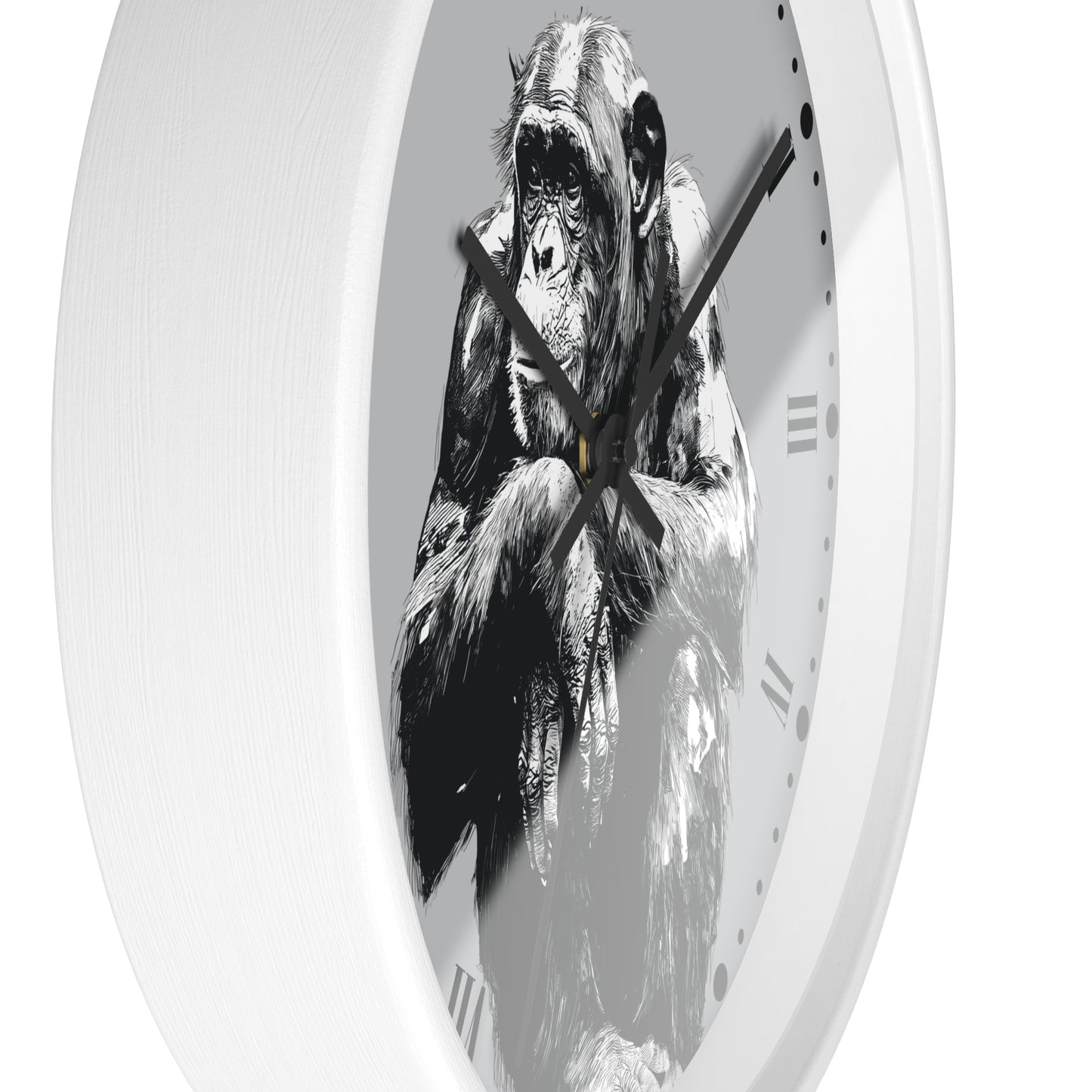 A white round wall clock featuring a black and white illustration of a chimpanzee on the face of the clock, with black hands and Roman numeral hour markers.