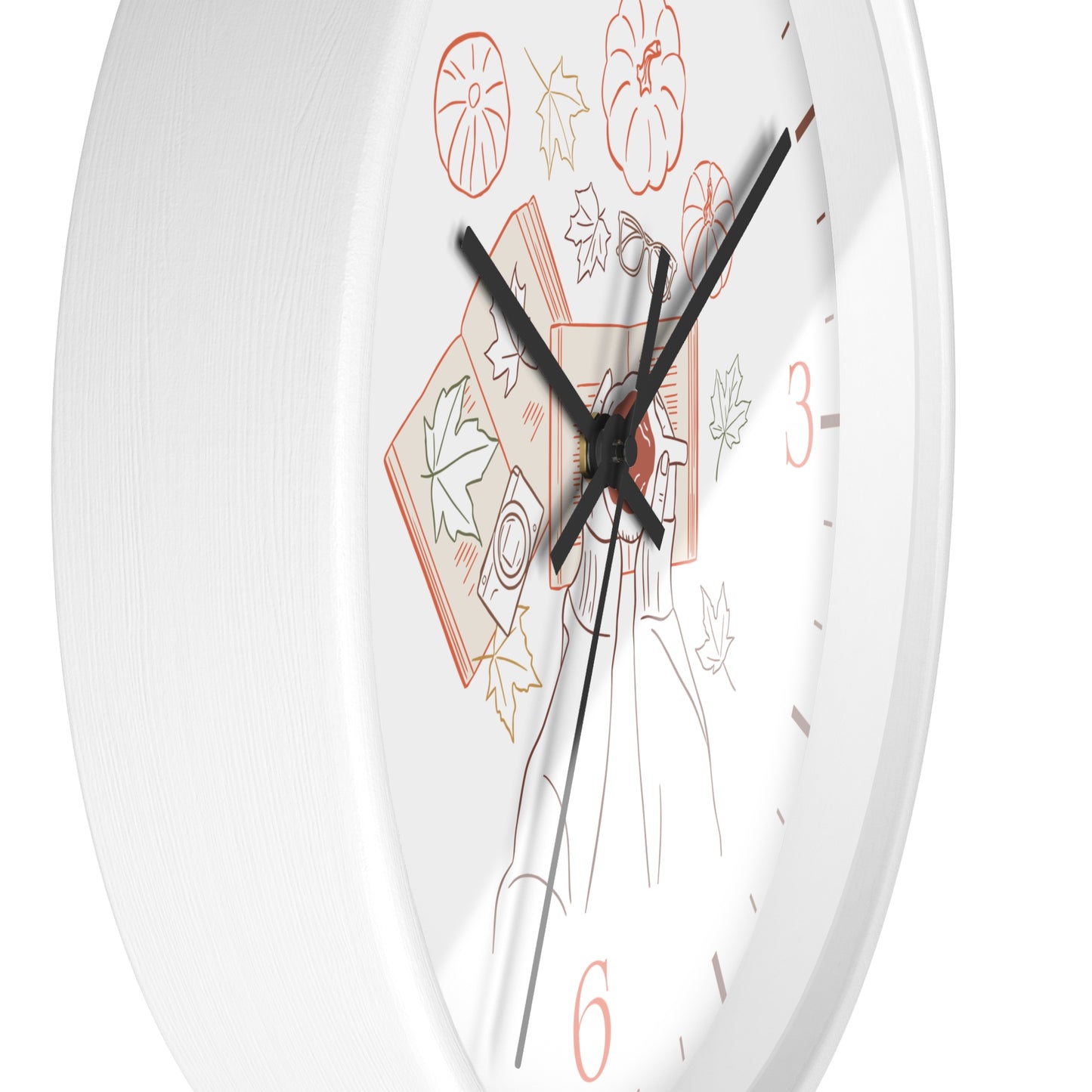 A close-up of a white round wall clock face with black hands and a minimalist autumn-themed illustration featuring orange numerals and leaf motifs.