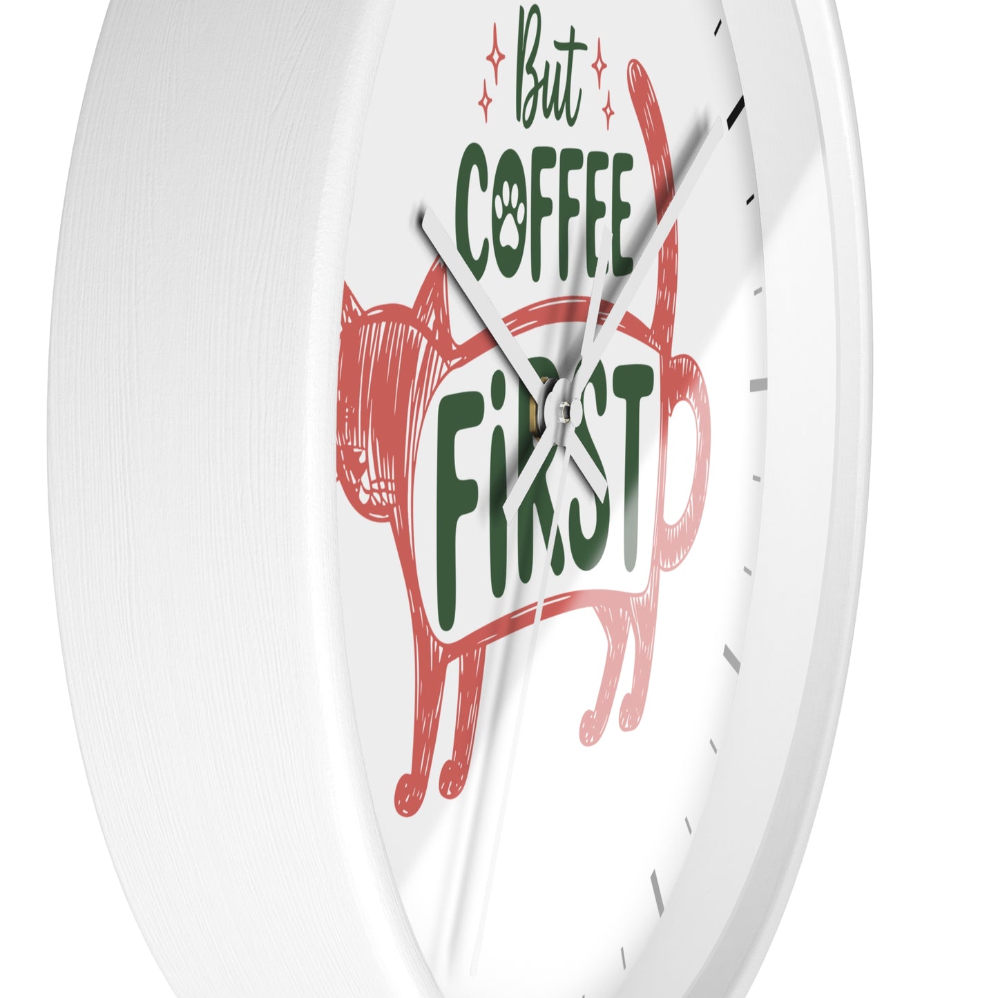 A white round wall clock with a minimalist design, featuring a red hand-drawn cat silhouette and the phrase 'But COFFEE FIRST' in green and black text on a clean white face.
