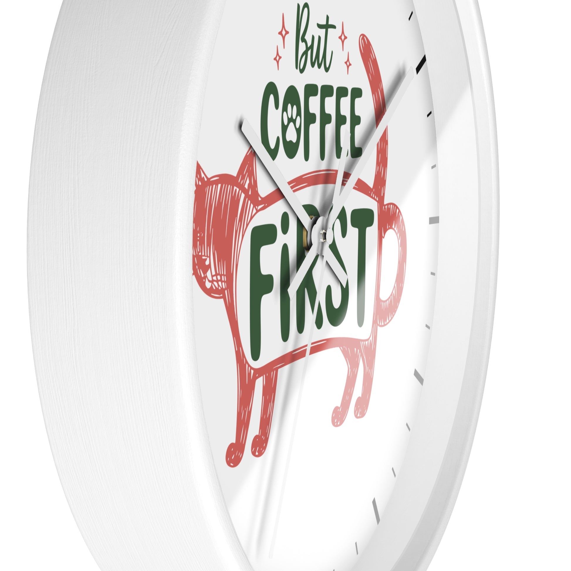 A white round wall clock with a minimalist design, featuring a red hand-drawn cat silhouette and the phrase 'But COFFEE FIRST' in green and black text on a clean white face.