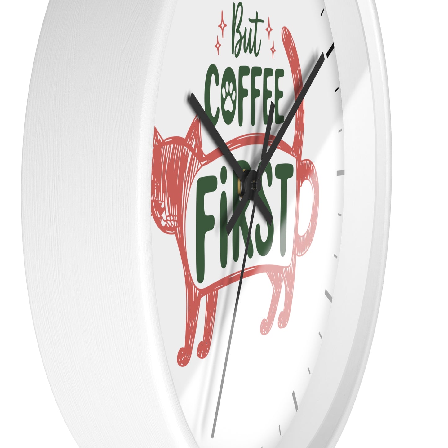 A white round wall clock with a minimalist design, featuring a red cat silhouette and the text 'But COFFEE FIRST' in green and black on the clock face.