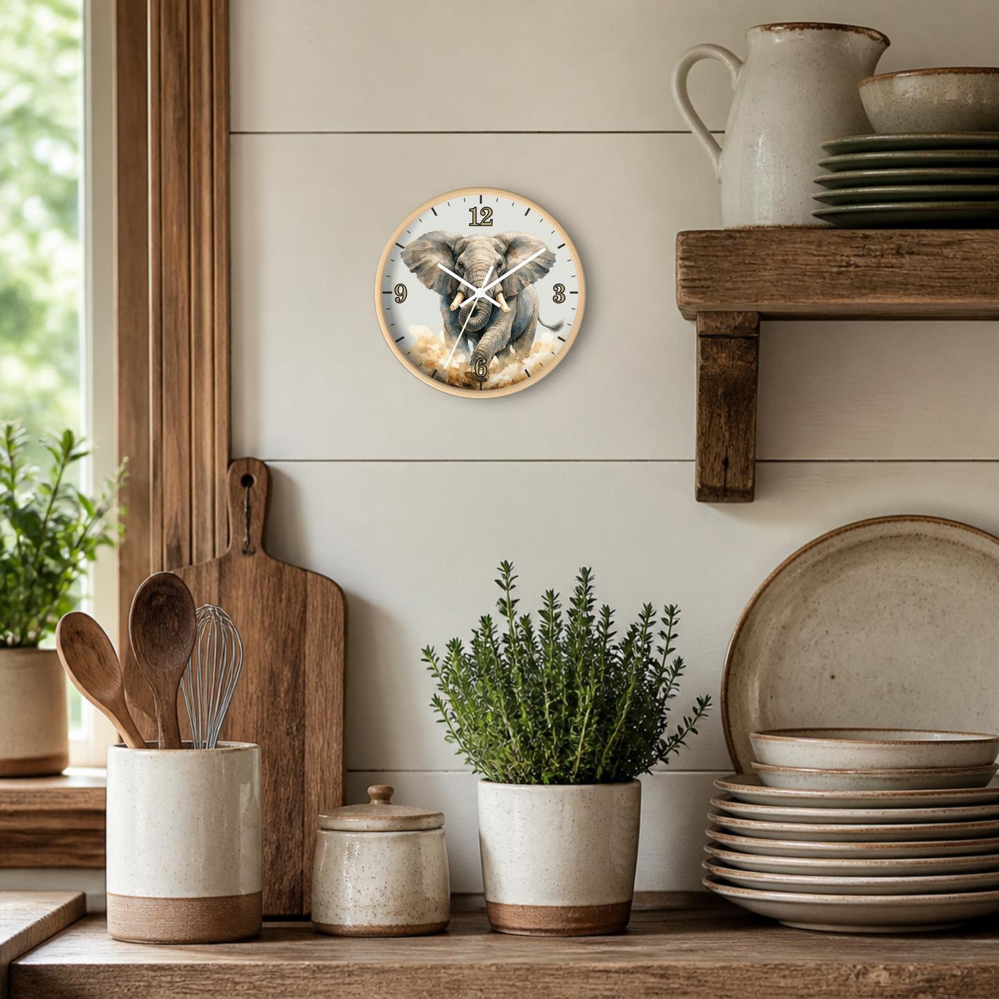 A round wall clock featuring a detailed illustration of a brown elephant, styled on a light beige shiplap wall above a rustic wooden shelf with ceramic dishes and plants.
