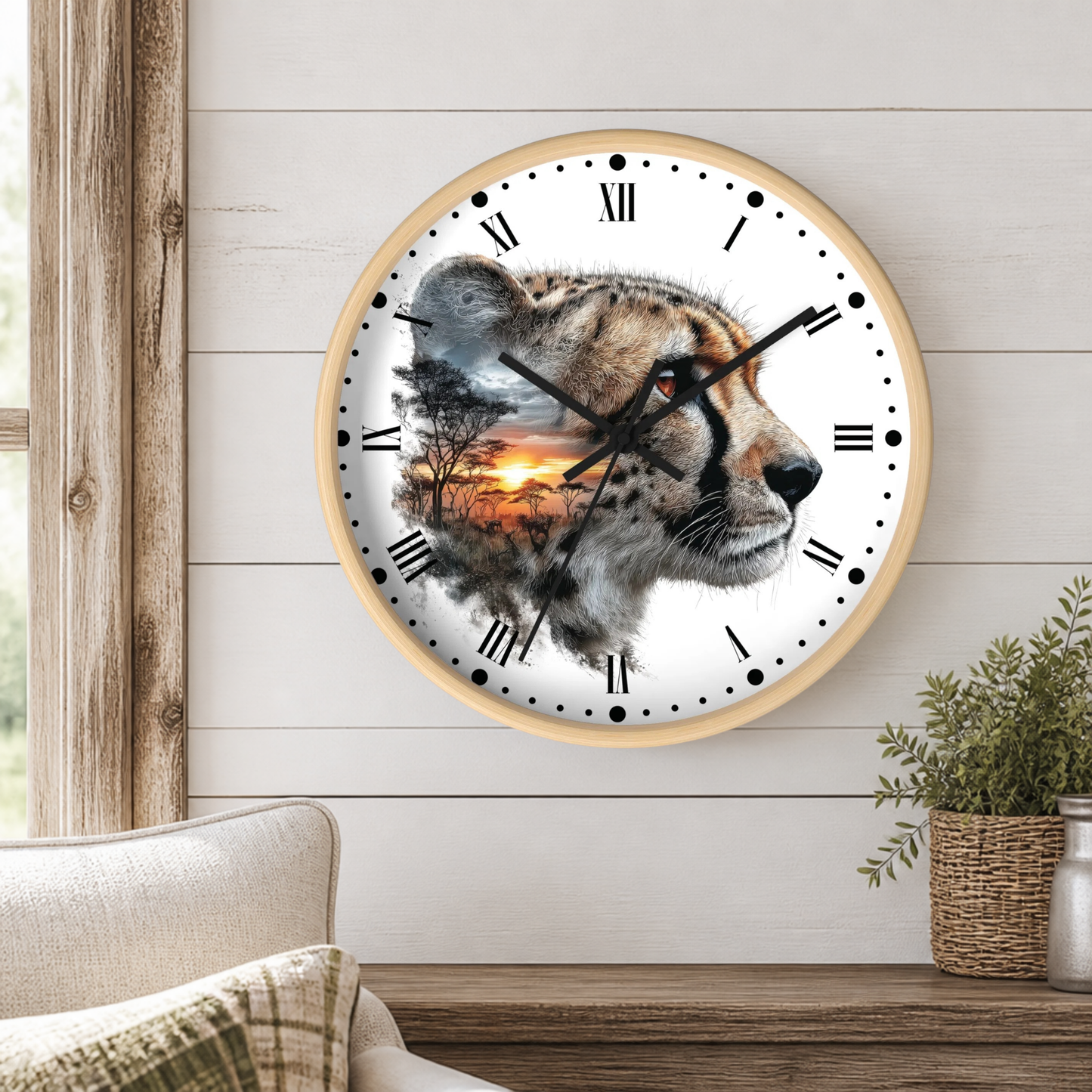 A round wall clock with a light wood frame hangs on a white shiplap wall above a wooden table. The clock face features a photographic cheetah head with a sunset landscape double-exposed print.